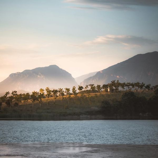 A serene landscape with a calm lake at sunrise symbolizing well-being.